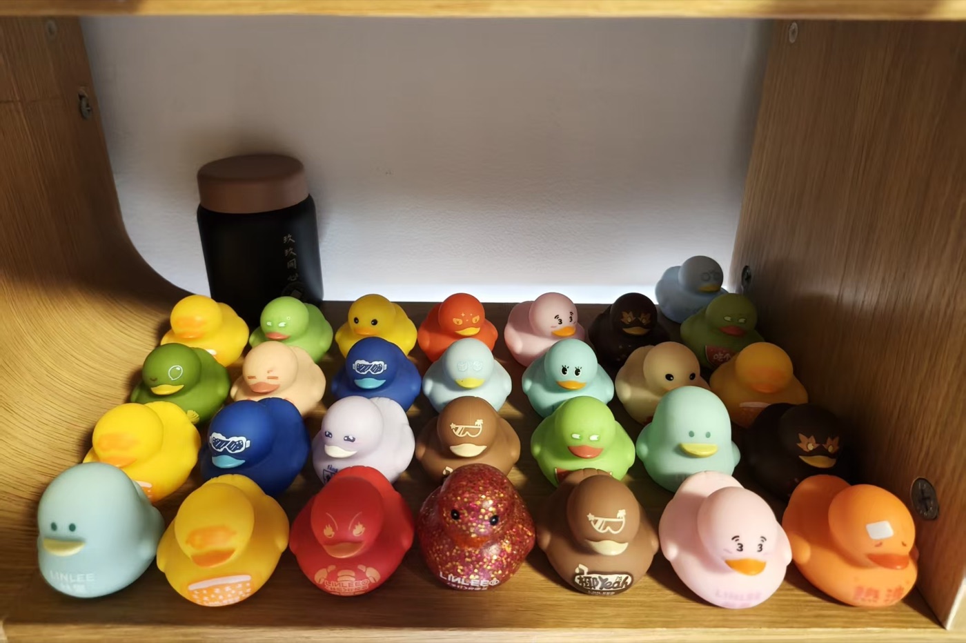 A colorful collection of small LINLEE Lemon Tea ducks arranged on a shelf